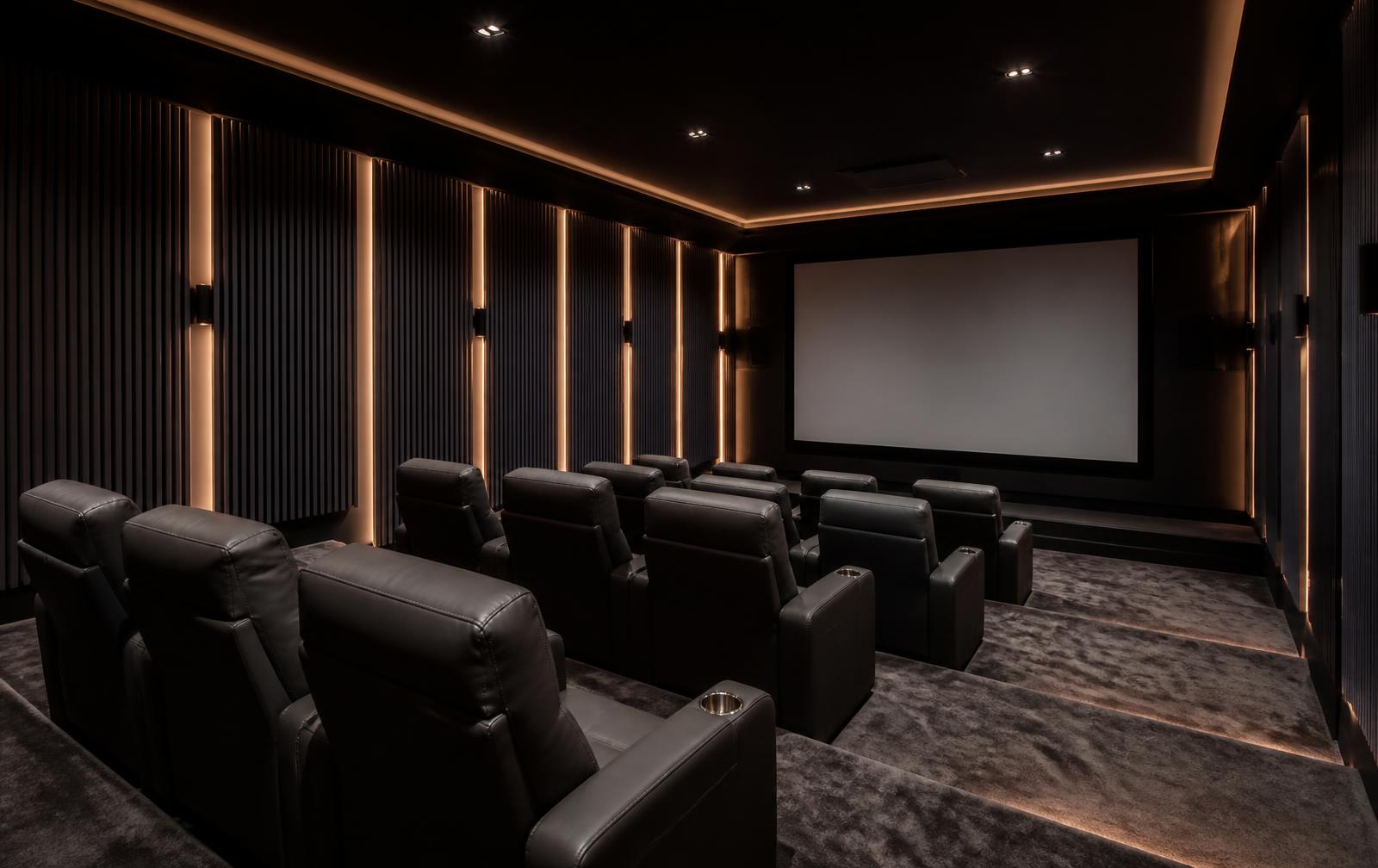 Dark acoustic fluted slat panels with warm LED lighting in a home movie theater room
